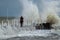 Girl makes extreme selfie on the pier against the background of waves with a risk to life