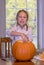 Girl makes a face as she touches slimy pumpkin