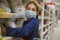 Girl makes stock of products. Reaching food shelf