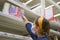 Girl makes stock of products. Reaching food shelf