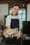 The girl making a cake in an apron shows a small cake baking pan to the camera