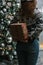 Girl making christmas surprise - holding gift behind a back.