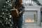 Girl making christmas surprise - holding gift behind a back.