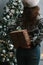 Girl making christmas surprise - holding gift behind a back