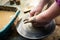 Girl making a clay bowl on sculpting wheel