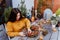 Girl making floral autumn door wreath using colorful rosehip berries, rowan, dry flowers and pumpkins