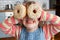 Girl Making Glasses Using Sugary Doughnuts