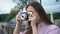 Girl making photo with vintage camera, city tour, vivid impressions, inspiration