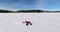 Girl making snow angel on frozen lake having fun in winter wonderland nature landscape, Young woman doing snowangel