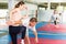 Girl with male opponent practicing elbow and knee strikes while locking arm