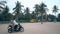 Girl and man appear on asphalt square riding motorbike