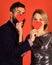 Girl and man with happy faces play with paper hearts