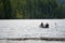 Girl and man with husky dog on kayak with oars in their hands are floating on the waves to go fishing on Lake Merwin with green