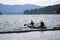 Girl and man with husky dog on kayak with oars in their hands overcame log breakwater on Lake Merwin and go fishing