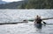 Girl and man with husky dog on kayak with oars in their hands overcome breakwater of logs on Lake Merwin