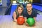 Girl and man lie on parquet in bowling club