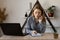 Girl manager of an online store takes an online order by mobile phone while sitting at a table with a laptop at work