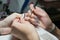 Girl manicurist paints nails.