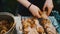 A girl is marinating a chicken kebab. Recreation, nature, summer, fresh air. Multicolored manicure on the hands.