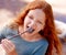 Girl, marshmallow and eating in nature, camping holiday and fire for roast snack in forest. Red hair, teenager and