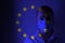 Girl in a mask against the background of the EU flag. Fear of illness, corona virus 2019-2020. Virus, outbreak and mass disease,