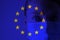 Girl in a mask against the background of the EU flag. Fear of illness, corona virus 2019-2020. Virus, outbreak and mass disease,
