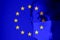 Girl in a mask against the background of the EU flag. Fear of illness, corona virus 2019-2020. Virus, outbreak and mass disease,