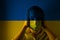 Girl in a mask against the background of the Ukraine flag,, danger and threat, outbreak of a dangerous. Photo