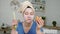 Girl with mask on face happy eating hamburger in kitchen