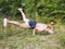 Girl in a mask performs a handstand in the middle of the forest. Sport in nature