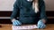 Girl in medical blue gloves and medical mask write the word `virus` with red lipstick on a white blank sheet.