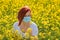 A girl in a medical mask in a field with flowers, protects herself from an allergy to pollen from plants. Coronavirus concept
