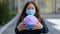 Girl in a medical mask and a globe in hands