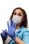 A girl in a medical mask, gloves and a robe on a white background. Beautician, beauty specialist. White-blue tones photo