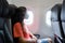 A girl in a medical mask on her face during a flight in the cabin. Air travel during a pandemic