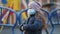 A girl in a medical mask. Her mother sprays disinfectant on her hands in the Playground. The concept of protection against