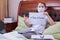 A girl in medical mask holds sheet of paper with words stay at home. A school girl does homework, distance learning, during covid-