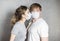 A girl in a medical mask kisses. A couple in love, a man and a woman kiss each other in a protective medical mask on their face.