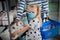 Girl with medical mask and mother buying toilet paper in shop