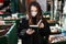 Girl in medical mask reads a book in a street library