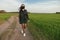 A girl in a medical mask runs or walks on a green field. Quarantine spring summer. coronavirus. COVID 19. Flu virus, colds