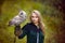 Girl in medieval dress is holding an owl on her arm