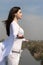 Girl meditates on a hill against the blue sky.