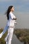 Girl meditates on a hill against the blue sky.