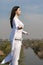 Girl meditates on a hill against the blue sky.