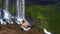 Girl meditates in pranayama yoga pose on stone at waterfall