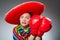 The girl in mexican vivid poncho and box gloves