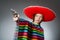 The girl in mexican vivid poncho holding handgun