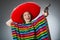 The girl in mexican vivid poncho holding handgun