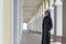 Girl of Middle Eastern appearance in Muslim clothes standing in the city gallery